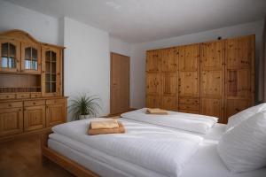 two beds in a bedroom with wooden cabinets at Salzleckerhof in Lambach
