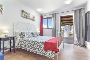a bedroom with a bed with a red blanket at Las Palmeras 2 in Güimar