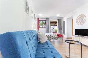a blue couch in a living room with a bed at Las Palmeras 2 in Güimar