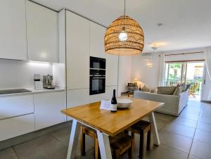 a kitchen and dining room with a table with a bottle of wine at 1A The Apartment in Albufeira