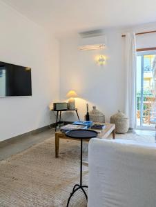 a living room with a couch and a tv on a wall at 1A The Apartment in Albufeira