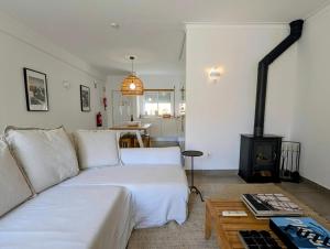 a living room with a white couch and a fireplace at 1A The Apartment in Albufeira +17 photos