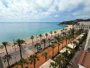 a view of a beach with palm trees and the ocean at Hotel Excelsior in Lloret de Mar