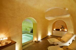 un bagno con vasca nell'angolo di una camera di Andromeda Villas & Spa Resort a Imerovigli