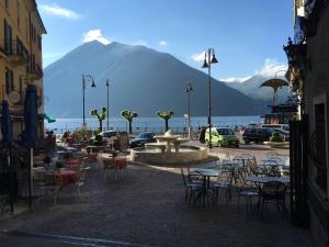 a courtyard with tables and chairs and a fountain with a mountain at Il nido di Argegno in Argegno