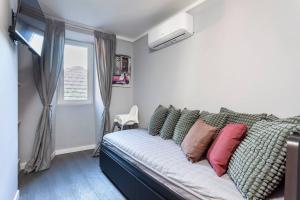 a bedroom with a couch with pillows and a window at Il nido di Argegno in Argegno