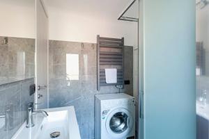 a bathroom with a washing machine and a sink at Il nido di Argegno in Argegno +19 photos