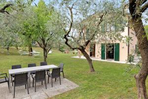 a table and chairs in a park with trees at Casa Alessandra in Torri del Benaco