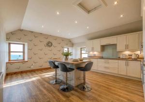 a kitchen with a table and two stools at North Lodge - NC500 in Helmsdale