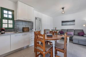 a kitchen and a dining room with a table and a couch at Heiwa Apartment With Pool in Costa Calma