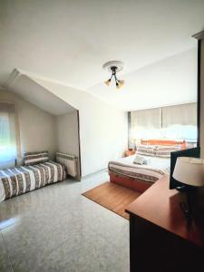 a bedroom with two beds and a ceiling fan at Apartamento en las afueras in Ribadeo