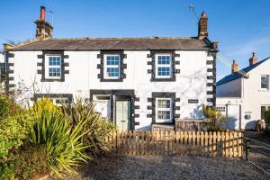 an old house with a fence in front of it at The Old Ale House in Craster