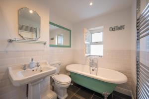 a bathroom with a tub and a toilet and a sink at The Old Ale House in Craster +14 photos