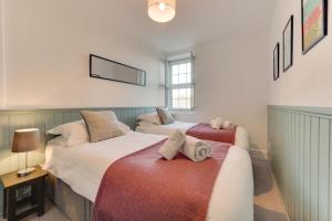 a bedroom with two beds with towels on them at The Old Ale House in Craster