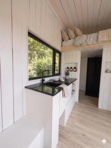 una cucina in una piccola casa con un lavandino di Stuga a Érezée Altre 14 foto