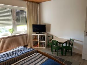 a bedroom with a bed and a table with a television at Ferienwohnung Wartehof in Bad Emstal