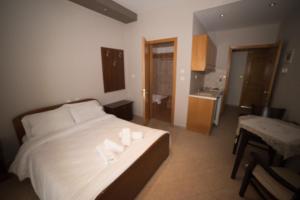 a bedroom with a bed with two towels on it at Hotel Galaxias in Kato Loutraki