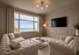a living room with two couches and a large window at North Lodge - NC500 in Helmsdale