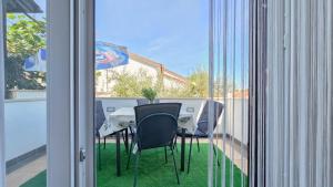 a table with chairs and an umbrella on a balcony at Ivanka A2 in Dajla