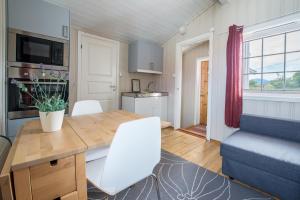 a kitchen and living room with a table and a couch at Lysø naturcamping og rorbuer in Averoy +6 photos