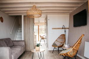 a living room with a couch and chairs at Breezand Beachhouses in Vrouwenpolder