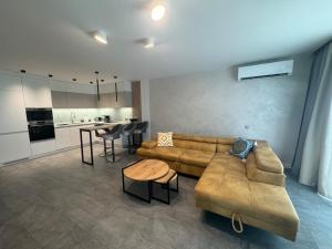 a living room with a couch and a table and a kitchen at Апартамент АТЕА in Kavarna