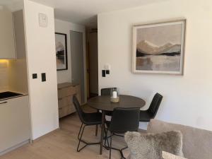 a kitchen and a dining room with a table and chairs at Dents Blanches B103 by Avecoeur in Morzine