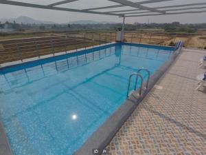 a large swimming pool with blue water at Hotel Hampi International in Hospet