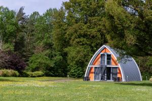 an orange and gray dome shaped house in a field at Gästehaus am Lausitzring in Poley