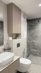 a bathroom with a toilet and a sink and a shower at Апартамент АТЕА in Kavarna +85 photos