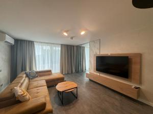 a living room with a couch and a flat screen tv at Апартамент АТЕА in Kavarna