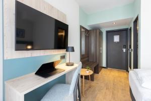 a living room with a large tv on a wall at Hotel Continental Frankfurt in Frankfurt