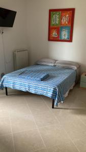 a bed in a bedroom with a blue blanket on it at Le Persiane Azzurre ovest in Albiano