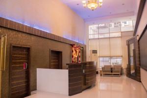 a lobby of a building with a waiting area and a couch at Hotel Orchard in Pune