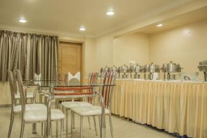 a room with a table and chairs and pots and pans at Hotel Orchard in Pune