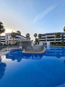 a large swimming pool with blue water in front of a building at Flamenca Village Apartment SALSA in Orihuela Costa