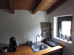 a kitchen counter with a sink and a window at Casa Rústica, perto do Castelo de Óbidos in Óbidos