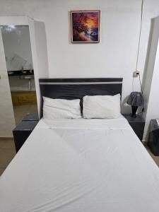 a bed with white sheets and pillows in a room at Ypane Residencial in Ypane