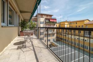a balcony with a table and chairs on a building at Urbanicooh Cavour Rooms&Suite in Bologna