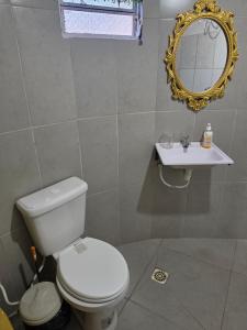 a bathroom with a white toilet and a sink at Ypane Residencial in Ypane +10 photos