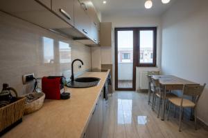 a kitchen with a counter and a table and chairs at Barrique 30 - Breakfast Delivered & Minibar - Free parking - Mall Area in Braşov