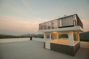a small house with a balcony on the roof at Verdant Crestwood Nilgiris in Coonoor