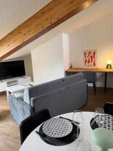 a living room with a couch and a table at Le Pompidou Clim - Parking - Terrasse - Centre in Albi
