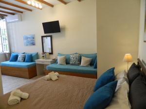 a living room with a blue couch and a tv at Perakis Apartments in Hydra