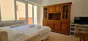 a bedroom with a bed and a tv and a cabinet at Monterosso - Apartment in Monterosso al Mare +7 photos