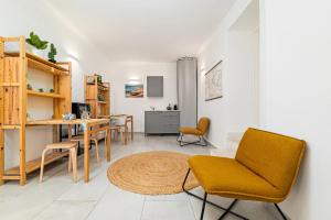 a living room with a table and chairs and a kitchen at Ghjlgolu Suites - Essential Stay in Monte Petrosu +21 photos