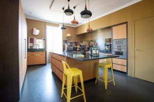 a kitchen with two yellow stools and a counter at Domaine des Chailloux in Jully-lès-Buxy