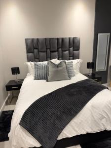 a bedroom with a large bed with a leather headboard at The paramount houghton Zayna in Johannesburg