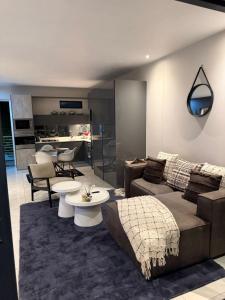 a living room with a couch and tables and a kitchen at The paramount houghton Zayna in Johannesburg