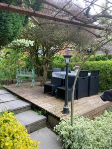 a garden with a table and chairs on a wooden deck at Ferienwohnung am Siel in Ditzum